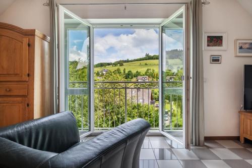 ein Wohnzimmer mit einem Sofa und einem großen Fenster in der Unterkunft Ols Berghaus in Olsberg
