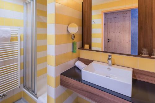 a bathroom with a sink and a mirror at JUFA Hotel Wipptal in Steinach am Brenner