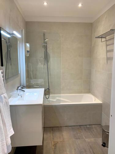 une salle de bain avec une baignoire et un lavabo dans l'établissement Share Inn Appartements, à Nice