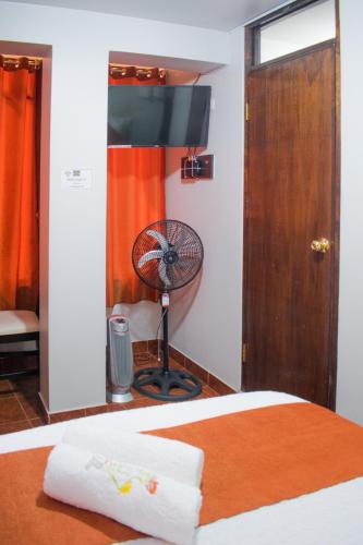 a bedroom with a bed with a fan next to a door at Machu Picchu Land in Machu Picchu