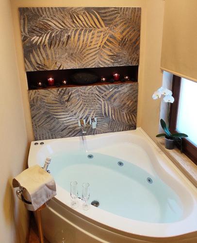 a bathroom with a tub with two wine glasses at B&B Betulla dell'Etna in Nicolosi