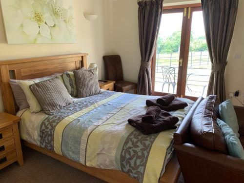 a bedroom with a bed with a chair and a window at Weatherhead Farm in Buckingham