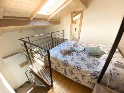een kleine slaapkamer met een bed en een trap bij New Agriloft 1 Nursery, giardino, clima e Wi-Fi a 50 mt dal mare in Bordighera