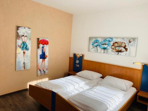 Ce lit se trouve dans un dortoir orné de 2 peintures murales. dans l'établissement Hotel Europa - Restaurant, à Rüsselsheim