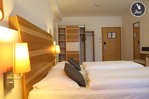 a hotel room with two beds and two lamps at arte Hotel Wien Stadthalle in Vienna