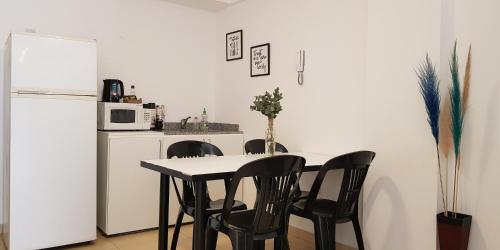 a kitchen with a table and two chairs and a refrigerator at L&B Departamento Excelente Ubicación in San Miguel de Tucumán