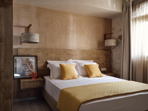 a bedroom with a large bed with yellow pillows at Casa Di Pietra in Gaïtánion