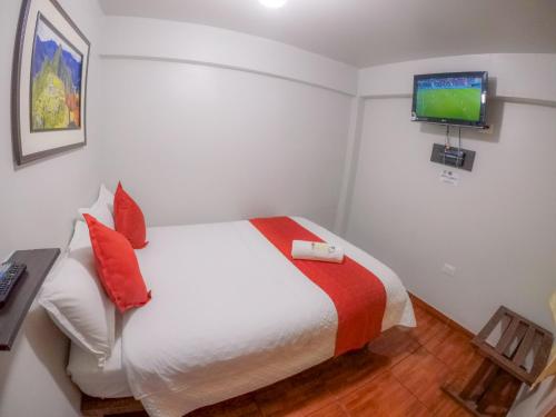 a bedroom with a bed with a television on the wall at Machu Picchu Land in Machu Picchu