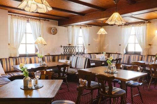 um restaurante com mesas e cadeiras de madeira e janelas em Hotel Eydt Kirchheim em Kirchheim