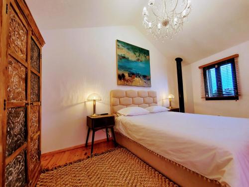 um quarto com uma cama e um lustre em Casa dos Jasmins by Lisbon Village Apartments em Covilhã