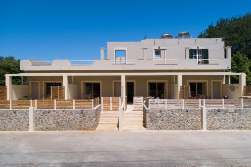 a large white house with a stone wall at Senses Suites in Dassia