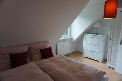 a bedroom with a white bed and a white dresser at Mirabella in Lüneburg