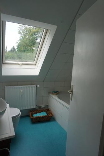 uma casa de banho com uma janela, um WC e uma banheira em Mirabella em Lüneburg