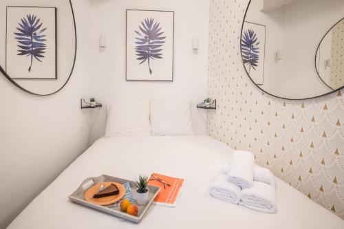 Cette chambre comprend deux miroirs et un lit avec un plateau/bouilloire. dans l'établissement WS Jardin du Luxembourg - Boissonade, à Paris