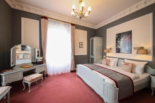a bedroom with a large bed and a window at Hotel Der Kleine Prinz in Baden-Baden