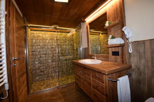 La salle de bains est pourvue d'un lavabo et d'une douche. dans l'établissement Chalet Jolie, à Livigno