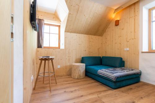 a room with a blue couch in a tiny house at Guesthouse & Camping Danica Bohinj in Bohinj