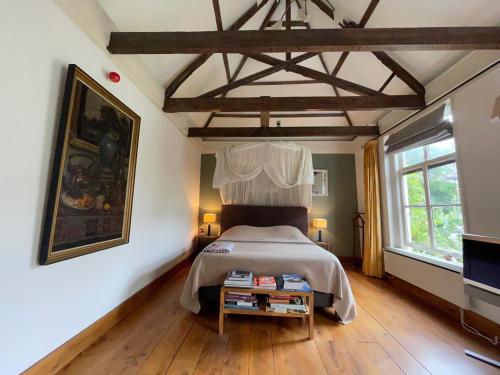 a bedroom with a bed and a table with books at Apple Tree Cottage - discover this charming home at beautiful canal in our idyllic garden in Gouda
