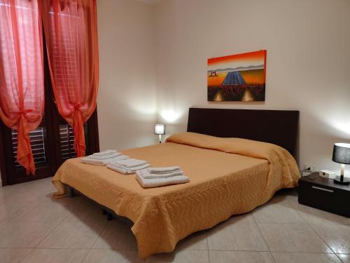 una camera da letto con un letto e due asciugamani di La Pineta San Vito Apartment a San Vito lo Capo