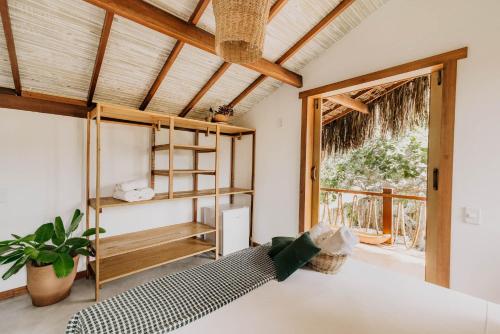 um quarto com uma cama e uma janela em Pousada Vila Verde Caraíva em Caraíva