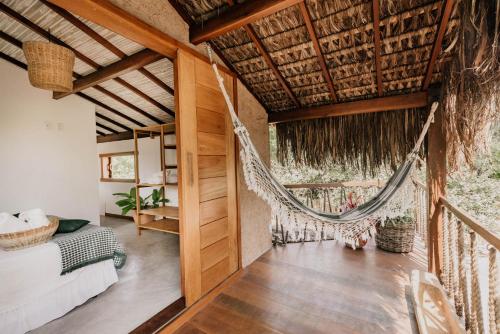 a room with a hammock in a house at Pousada Vila Verde Caraíva in Caraíva