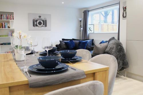 a living room with a table with plates on it at Didcot - Private Flat with Garden & Parking 07 in Didcot