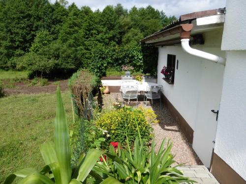 un patio con mesa y sillas en un jardín en Ferienwohnung Am Lindenrain, en Mossautal