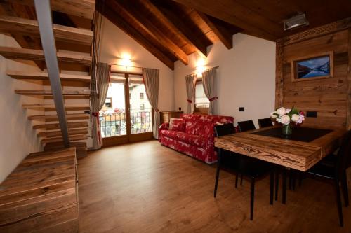 a living room with a red couch and a table at Chalet Jolie in Livigno