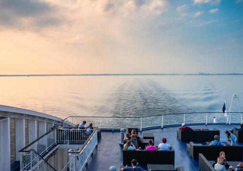 grupa ludzi siedzących na pokładzie łodzi w obiekcie Viking Line ferry Viking XPRS - One-way journey from Helsinki to Tallinn w Helsinkach
