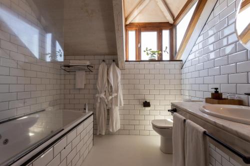 Un baño con lavabo, bañera e inodoro. en No-Mad Green Hotel, en Molinaseca