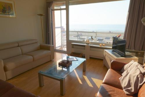ein Wohnzimmer mit einem Sofa und einem Couchtisch in der Unterkunft 'SPA' - Family Apartment with Amazing Seaview in Ostende