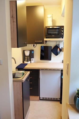 a small kitchen with a counter and a microwave at Ferienwohnung Kisslina in Bad Kissingen