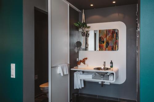 a bathroom with a sink and a mirror at Superbude Hamburg Altona in Hamburg