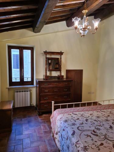 a bedroom with a bed and a dresser and a window at Casa vacanze Torre dell'orologio in Montefalco