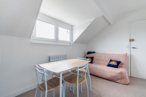 a room with a table and chairs and a couch at Appartement à 300m de la plage - Extérieur commun in Asnelles