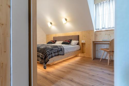 a bedroom with a bed and a wooden floor at Guesthouse & Camping Danica Bohinj in Bohinj