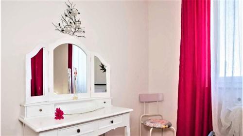 ein Badezimmer mit einer weißen Kommode und einem roten Vorhang in der Unterkunft Apartment Green Oasis 1 in Umag