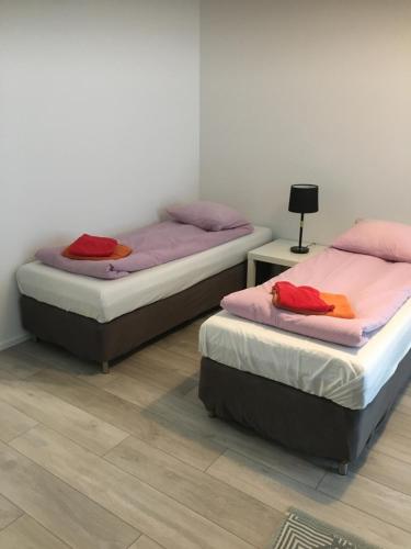 two twin beds in a room with two tables at apartment Juurikoskenkatu in Ylivieska