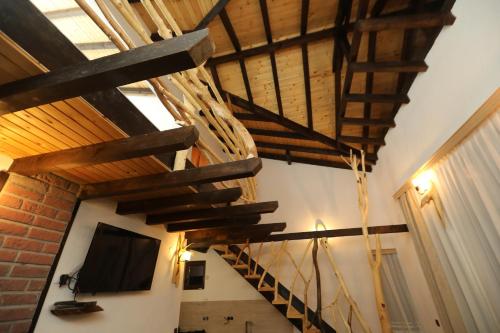a staircase in a room with wooden beams and a tv at Horlog Castle in Trigrad