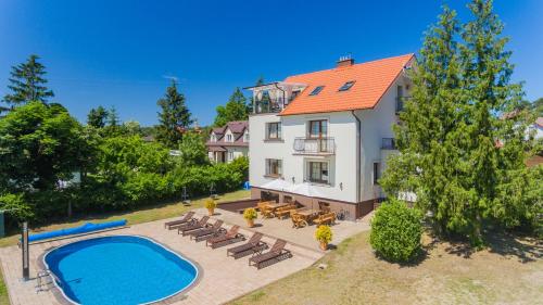 - une vue aérienne sur une maison avec une piscine dans l'établissement Bryza Jantar apartamenty z sauną & domki z kominkami, à Jantar