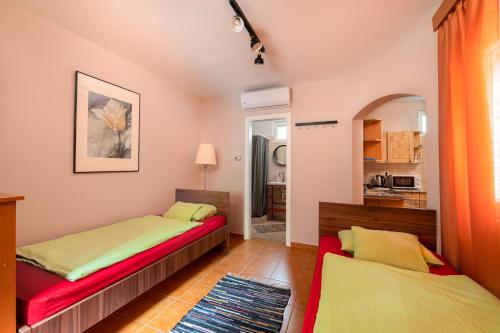 ハイドゥソボスローにあるMonika Apartmanのベッドルーム1室(ベッド2台付)、キッチンが備わります。