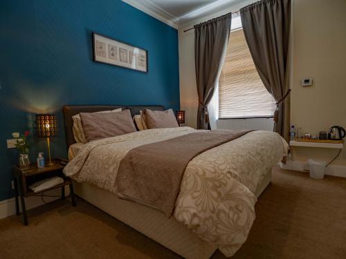 Un dormitorio con una cama grande y una ventana en The Old Cross Inn en Blairgowrie