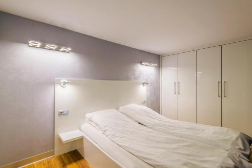 1 dormitorio con 1 cama blanca y armarios en Accent, en Nowy Dwór Gdański