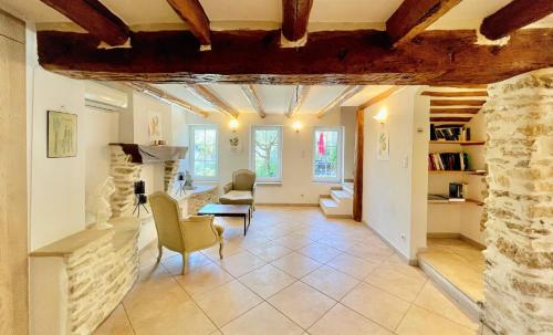 a living room with a stone wall and a table and chairs at Clos Saint-Michel Resort & Spa in Malaucène