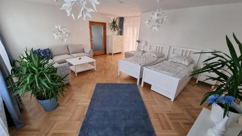 マルクアンシュテットにあるFerienwohnung Kirstenの白い家具と植物が備わるリビングルーム
