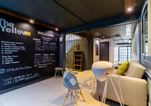 a room with a couch and chairs and a sign at The Yellow by DOT Boutique in Guadalajara