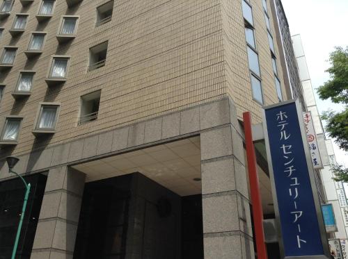 un edificio con una señal delante de él en Hotel Century Art en Fukuoka