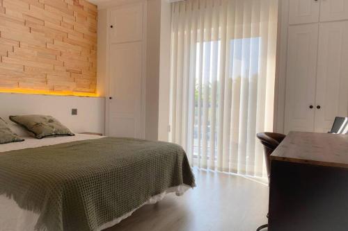 1 dormitorio con cama y ventana grande en Sevilla Torneo PG Apartamentos, en Sevilla