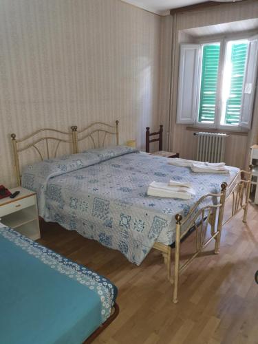 sypialnia z 2 łóżkami i 2 oknami w obiekcie HOTEL RISTORANTE NAPPINI w mieście Lizzano in Belvedere