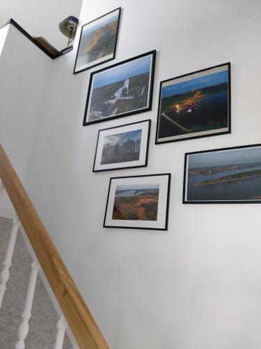 a group of pictures on a wall at Naktakės apartamentai in Kupiškis
